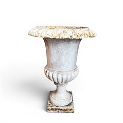 Pair of Victorian revival cast iron garden urns, egg and dart rim, tapering column with gadrooned waist, on square base, finished in distressed white paint