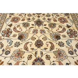 North East Persian Mashad hand-knotted carpet, ivory field decorated with an all-over scrolling floral vine design incorporating stylized palmettes, deer, rosettes and floral sprays enclosed by a conforming floral vine border between multiple guard stripes, cotton fringe ends