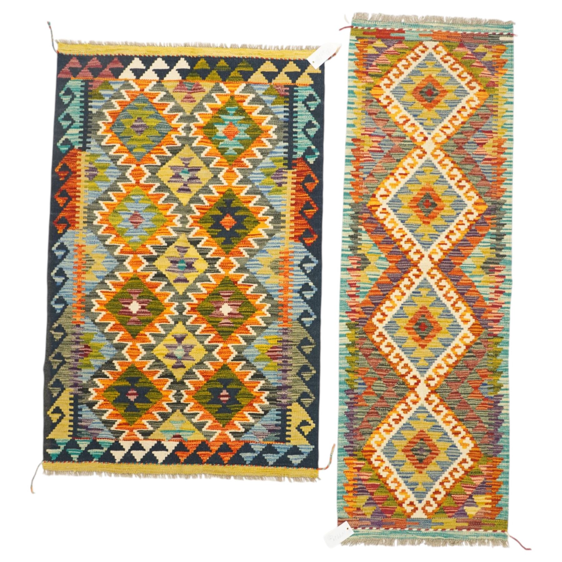 Afghan Maimana flatweave kilim and an Afghan Chobi flatweave kilim runner, with a repeating stepped diamond medallion design in ivory, green, rust, teal, purple, and indigo, framed by chevron and geometric borders, 153x50cm & 127x80cm, (2)