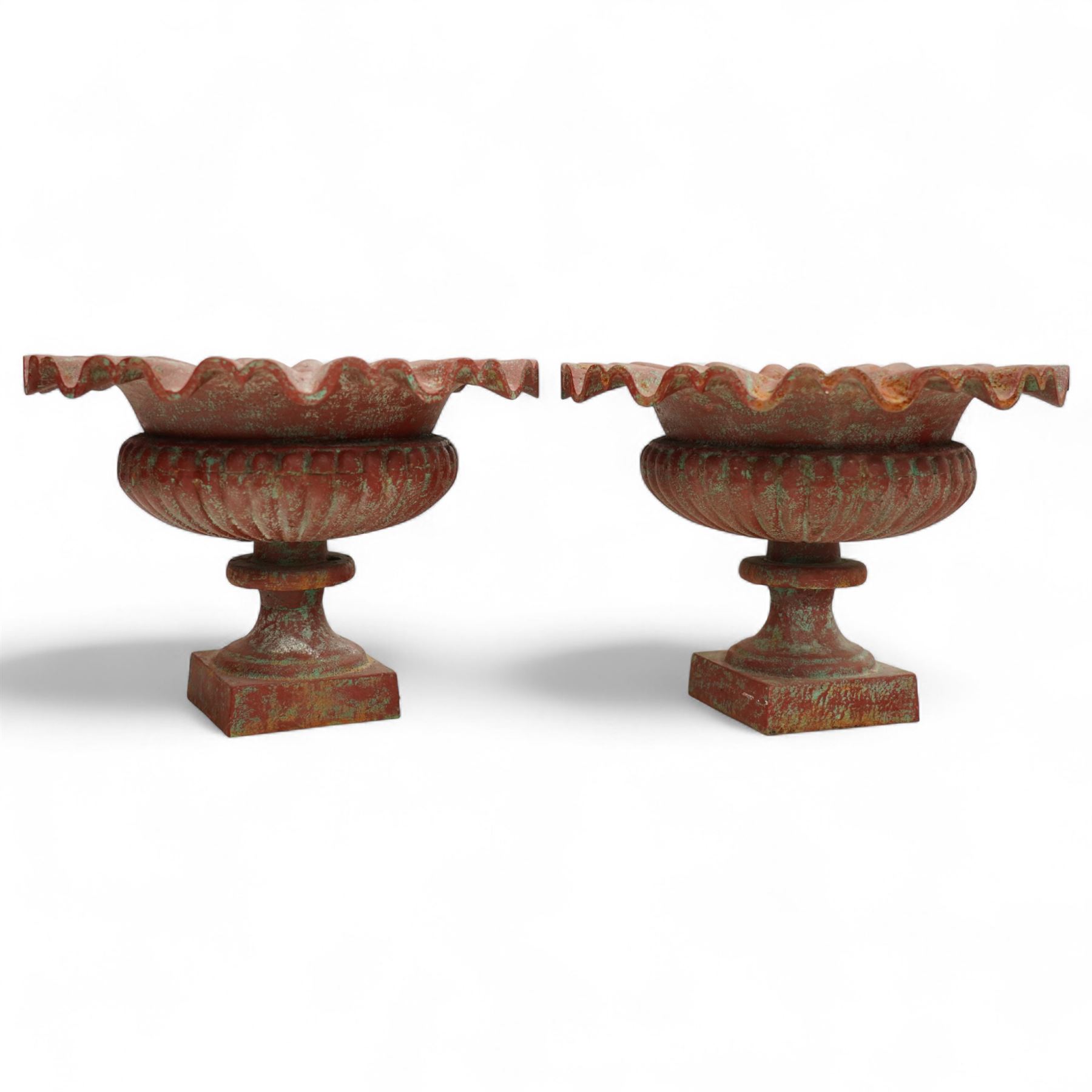 Pair of cast iron garden urns, each of flared form with crinkled edge rims and circular bodies, finished in aged red paint and raised on square bases