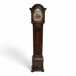 Oak cased 8-day grandmother clock c 1930 - with a broken arched pediment and break arch hood door flanked by turned pilasters, carved full length trunk door on a short plinth raised on bun feet, brass dial with cast spandrels, matted dial centre and silvered chapter with Roman numerals, three train spring driven movement chiming the quarters and hours on 8 gong rods.  With pendulum.