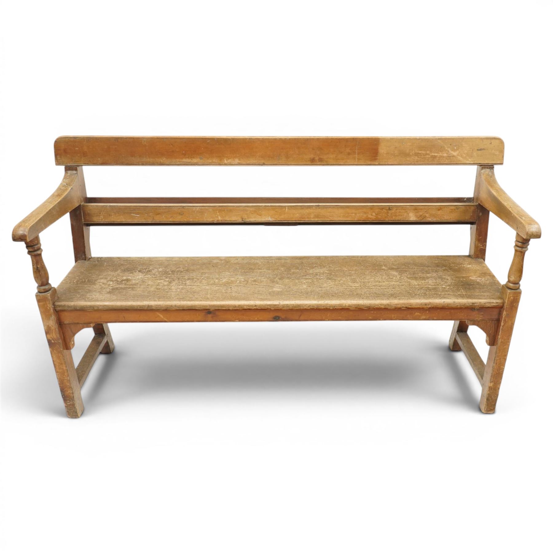 Early 20th century pine chapel bench, with moulded plank back rail over plain rail, with book storage to the back, open shaped end supports with curved arms, turned front uprights, plank seats, square legs united by low stretchers