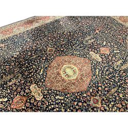 Persian design indigo ground carpet, central crimson pole medallion surrounded by trailing foliate decoration, the guarded border with repeating scrolling palmette motifs