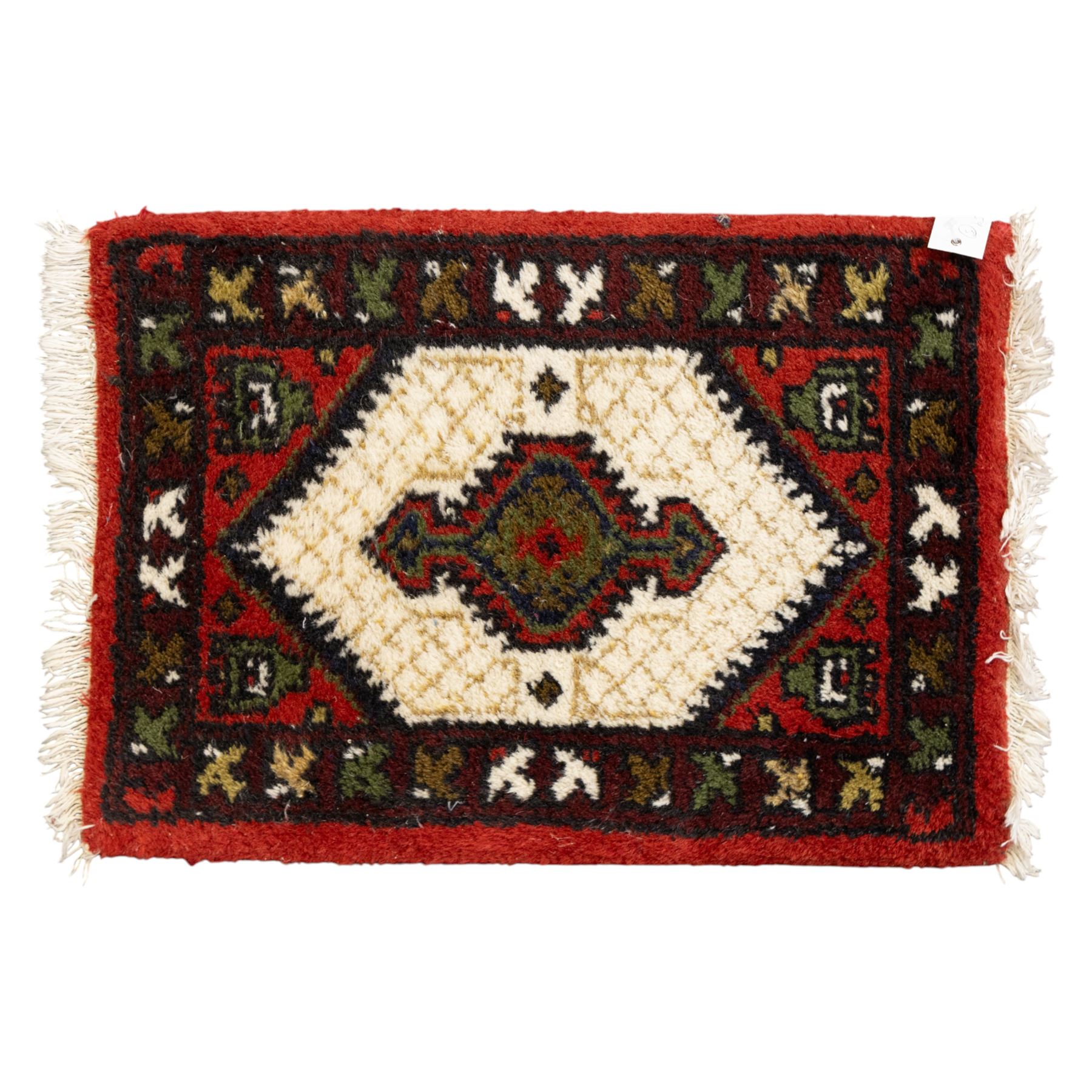 Long flatweave Kilim textile cushion, in crimson and decorated with geometric motifs and cotton fringe ends, 151cm, together with four modern hand-knotted rug mats with geometric designs, the largest 65x43cm, (5)