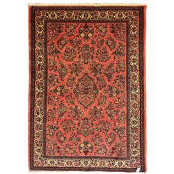 North West Persian Sarouk peach ground rug, the field decorated with floral bunches, pale ground border with repeating flower head motifs within guard stripes 