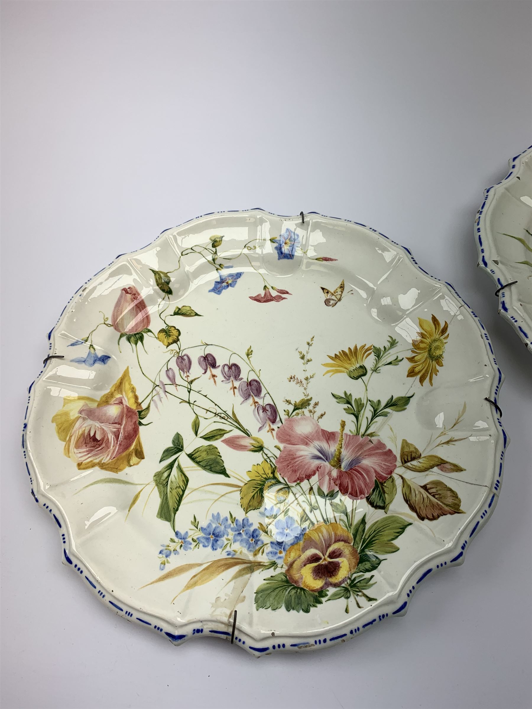 A pair of Italian faience pottery plates, by Giovanni Battista Viero, each of circular form with piecrust rim, with painted floral decoration, each with painted mark beneath, (a/f), D37.5cm