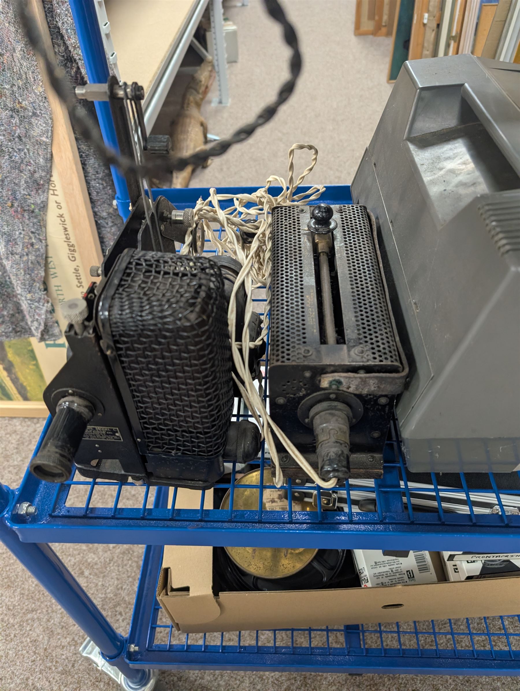 Collection of projectors, including Transpaque Junior overhead projector, Demo Comm 1 overhead projector, Bolex 18-9 Duo, Bolex 18-5, Pathescope Kid, Kodascope Model C, collection of video tapes and film reels, empty projector box, Kinay 816 editor, etc