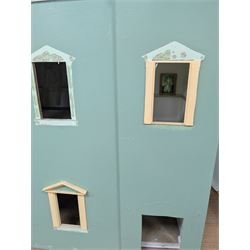 Two modern three storey dolls houses, each painted green with decorated interiors, both upon a single white wooden base, together with a large collection of dolls house furniture, accessories and figures 