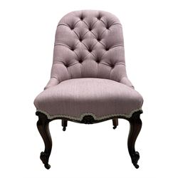 Victorian rosewood framed nursing chair, buttoned back and sprung serpentine fronted seat upholstered in mauve fabric, fan and scroll carved apron over cabriole supports and castors