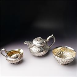 Matched three piece silver tea set comprising teapot of squat circular form London 1827,  milk jug of similar date and sugar bowl with Britannia standard marks, all with later embossed floral decoration and coat of arms, all marks rubbed