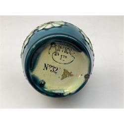 Minton Secessionist vase, with tube-lined stylised flower decoration, upon a blue ground, with printed mark to base 'Minton Ltd, No. 32', H13cm