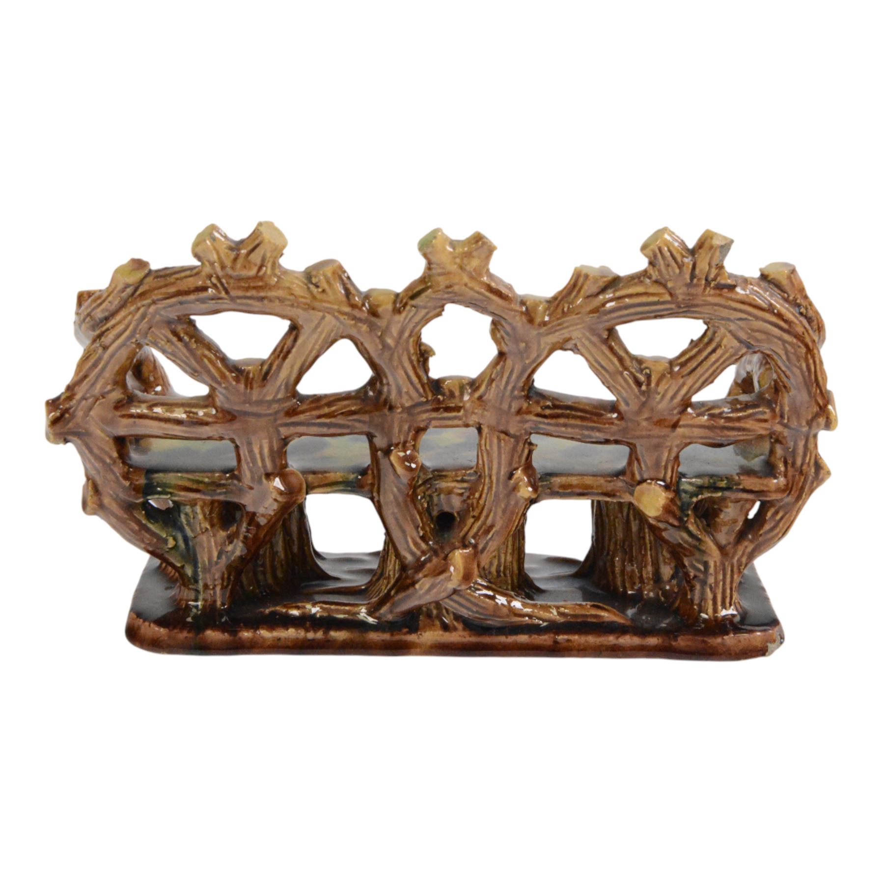 19th century pottery model of a bench, possibly Skey Pottery Tamworth, Staffordshire, the shaped seat mottled in shades of green, dark blue, yellow and brown, supported upon naturalistically modelled tree stumps, the arms and back modelled as intertwined branches, H14cm W21cm D10cm