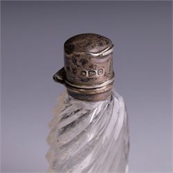 Three silver topped scent bottles, comprising cut glass example with pink guilloche enamel cover, oval example with blue guilloche enamel cover and one other, all hallmarked, largest H6.5cm