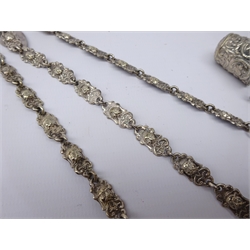 Early 20th century silver-plated Chantelaine, pierced scroll mount, three mask chains to a mask embossed scissor sheath, pin cushion & thimble and engine turned silver vesta, L24cm excluding attachments   