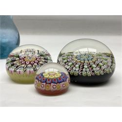 Three millefiori paperweights, together with a green glass dump paperweight with air bubble inclusions, Caithness Daisy and Cauldron paperweights and two small Caithness glass vases, tallest H9cm