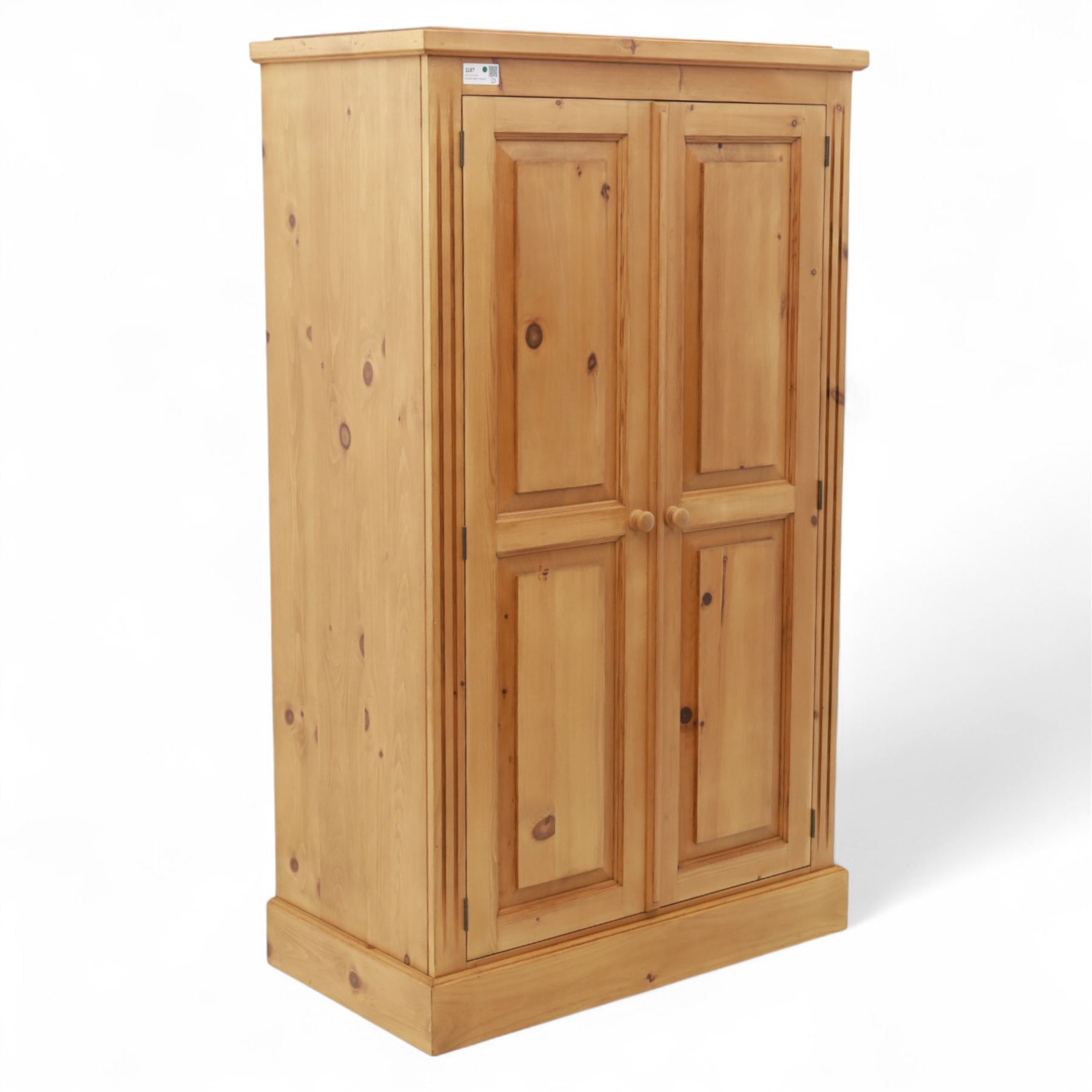 Modern stripped pine two-door wardrobe, the fielded panel doors with turned knob handles, opening to a double rail hanging interior, beneath a stepped cornice and raised on plinth base