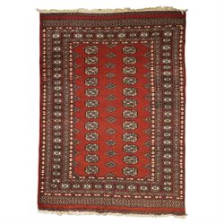 Turkoman hand-knotted rug, madder red ground with two rows of repeating octagonal guls int...