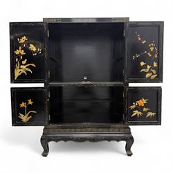 Late 20th century Chinoiserie black lacquer cabinet, the rectangular body decorated with hand-painted floral and foliate motifs in polychrome and gilt, fitted with four panel doors enclosing shelved interior, on shaped apron and stylised cabriole supports with gilt scrollwork