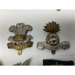 Fourteen cap badges of Irish interest including Royal Dublin Fusiliers inscribed to the slider 'From A. O'Connor 2nd Batt. Dec.2nd 1915', Connaught Rangers, South irish Horse Yeomanry, Inniskilling Fusiliers, Royal Irish Regiment etc; and seven Welsh badges including South Wales Borderers, Welsh Guards, 3rd Bn. Monmouthshire Regt. etc (21)