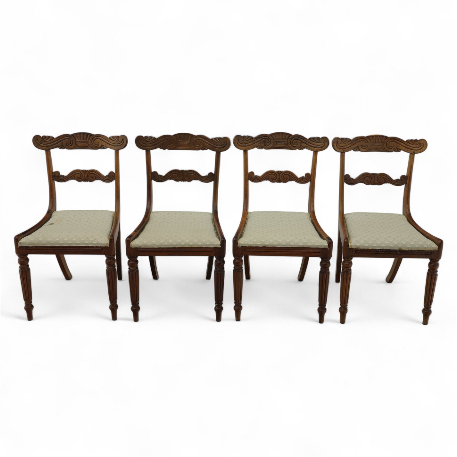 Set of four 19th-century rosewood dining chairs in the William IV style, shaped and carved top rail with fan and scroll decoration above a upholstered padded seat on reeded and turned front legs 