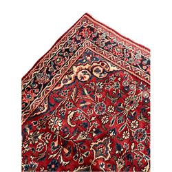 Persian Hamadan red ground rug, the field decorated with interlaced foliate and flower head motifs, repeating guarded border 