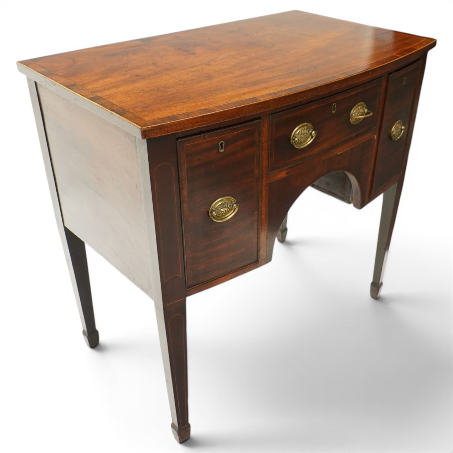 Small late 18th century inlaid mahogany sideboard, with bow fronted top with crossbanded edge, central drawer flanked by a drawer each side, kneehole cut out, raised on square tapering supports terminating in spade feet