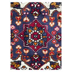 West Persian Hamadan rug, hand knotted, central medallion bordered by geometric and intricate floral motifs, displaying red cream and indigo colours with an orange coloured border  