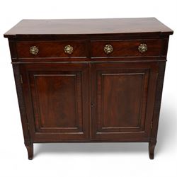 Regency mahogany cupboard, rectangular shaped top over two cock-beaded frieze drawers, fitted with brass Yorkshire rose pull handles, over two panelled and cross-banded cupboards, flanked by reeded uprights, raised on curved feet