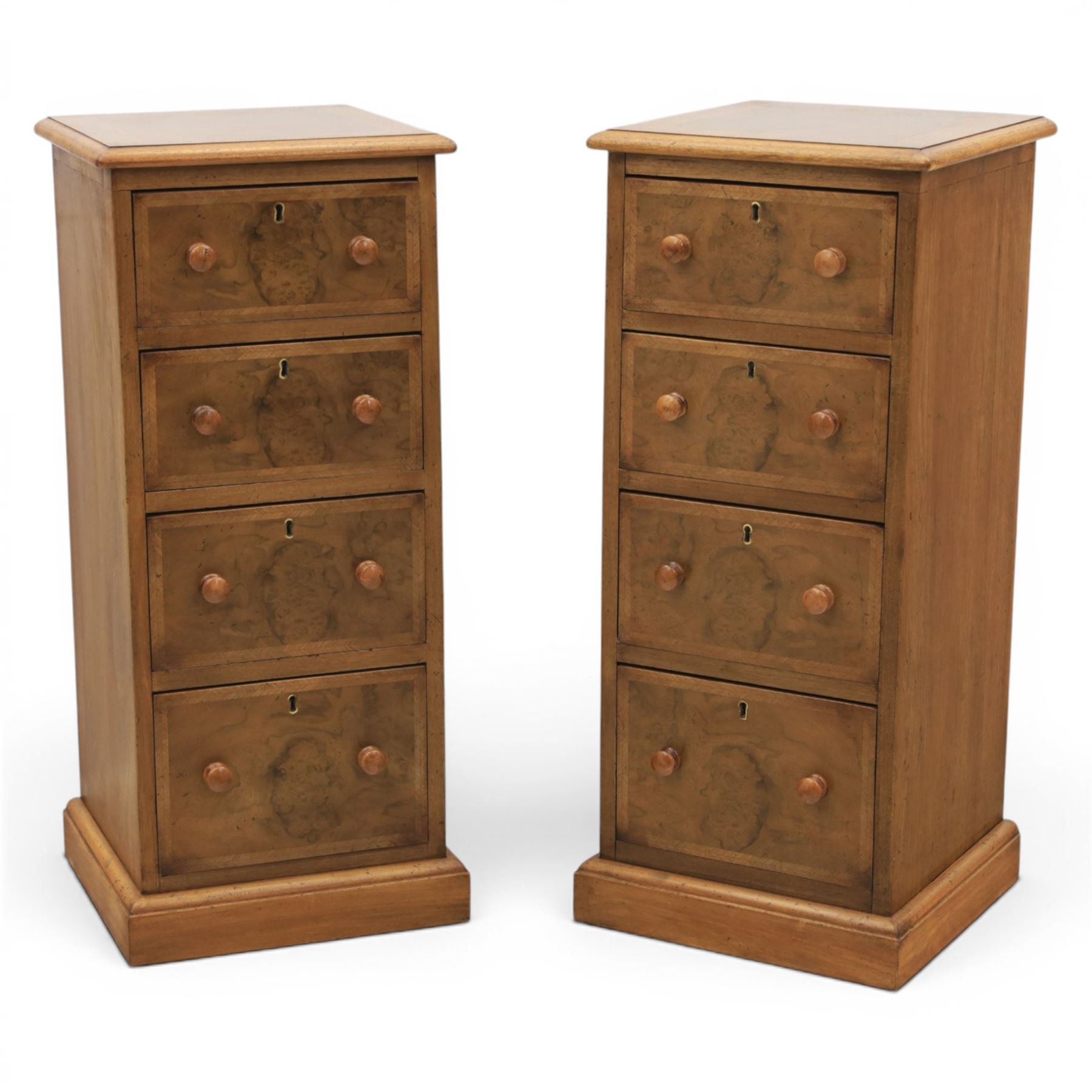 Traditional walnut inlaid pair of tall bedside chests, figured top with inlaid banding, four graduating drawers with wooden turned knobs, raised on a plinth  