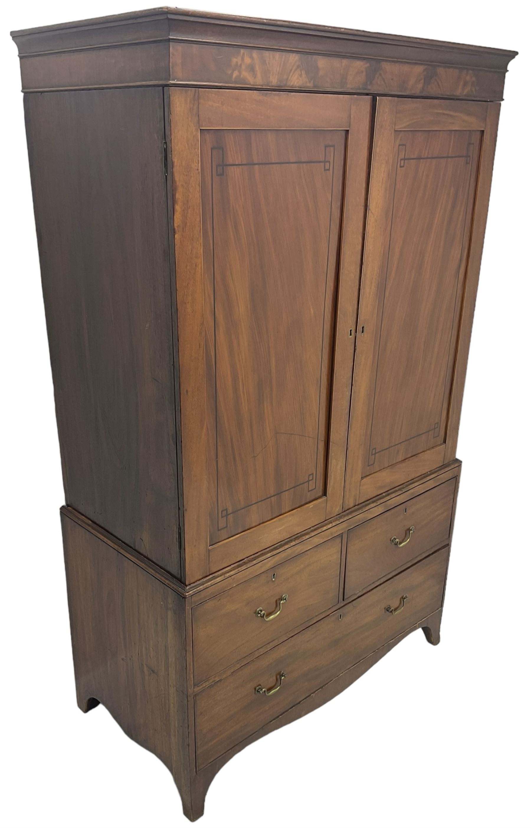 19th century mahogany linen press, projecting moulded cornice over figured frieze, enclosed by two panelled doors with geometric stringing, fitted with two short and one long cock-beaded drawers, on shaped apron and splayed bracket feet