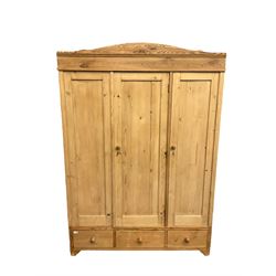 Early 20th century Continental pine triple wardrobe, arched cornice over three panelled doors and drawers