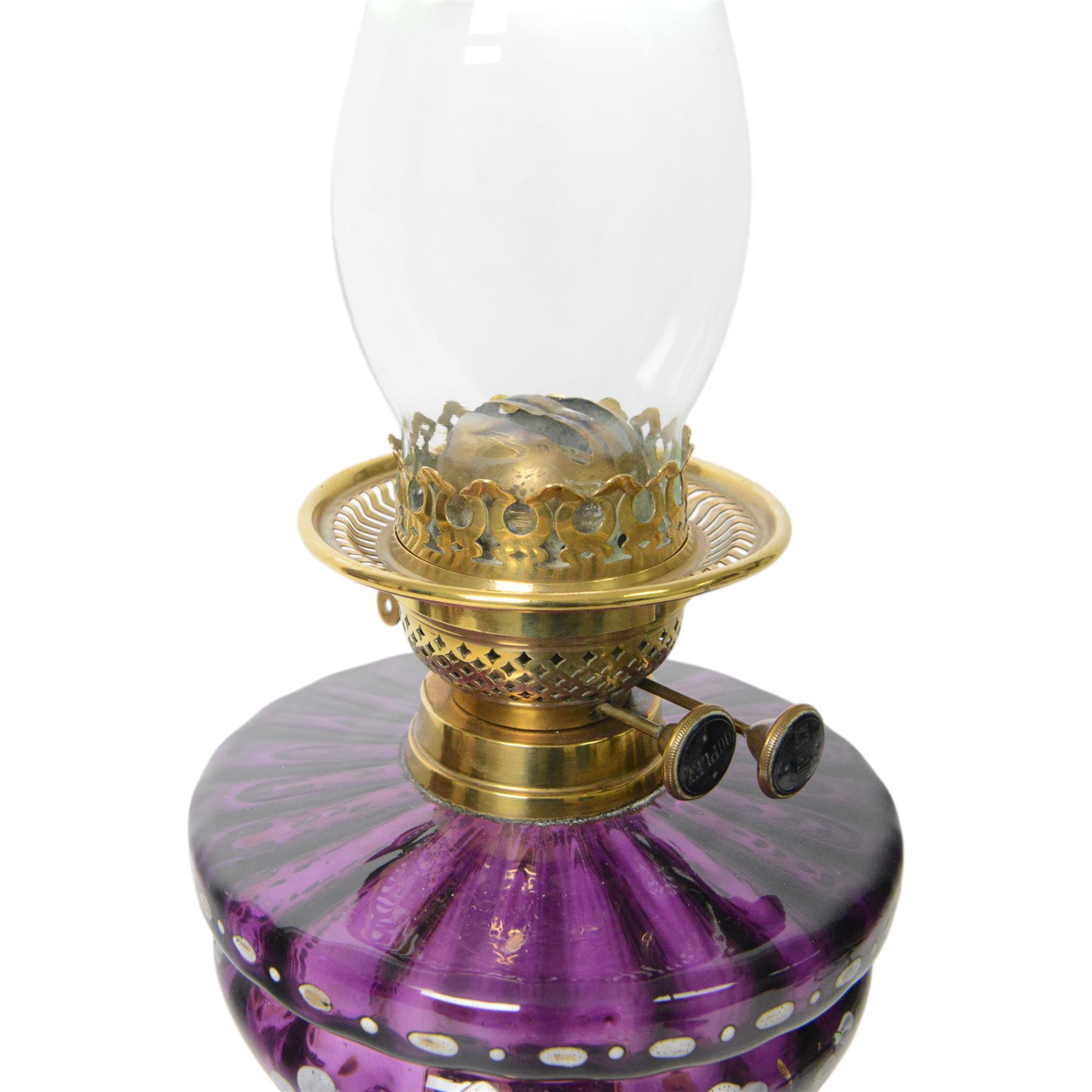 Victorian oil lamp, the brass base supporting a floral enamelled amethyst glass reservoir, duplex burner, and clear glass chimney, overall H69cm