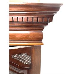 Late Victorian wardrobe, projecting dentil cornice, two carved doors flanking central shaped and bevelled mirror door, fitted interior including shelving and drawers, shaped plinth support