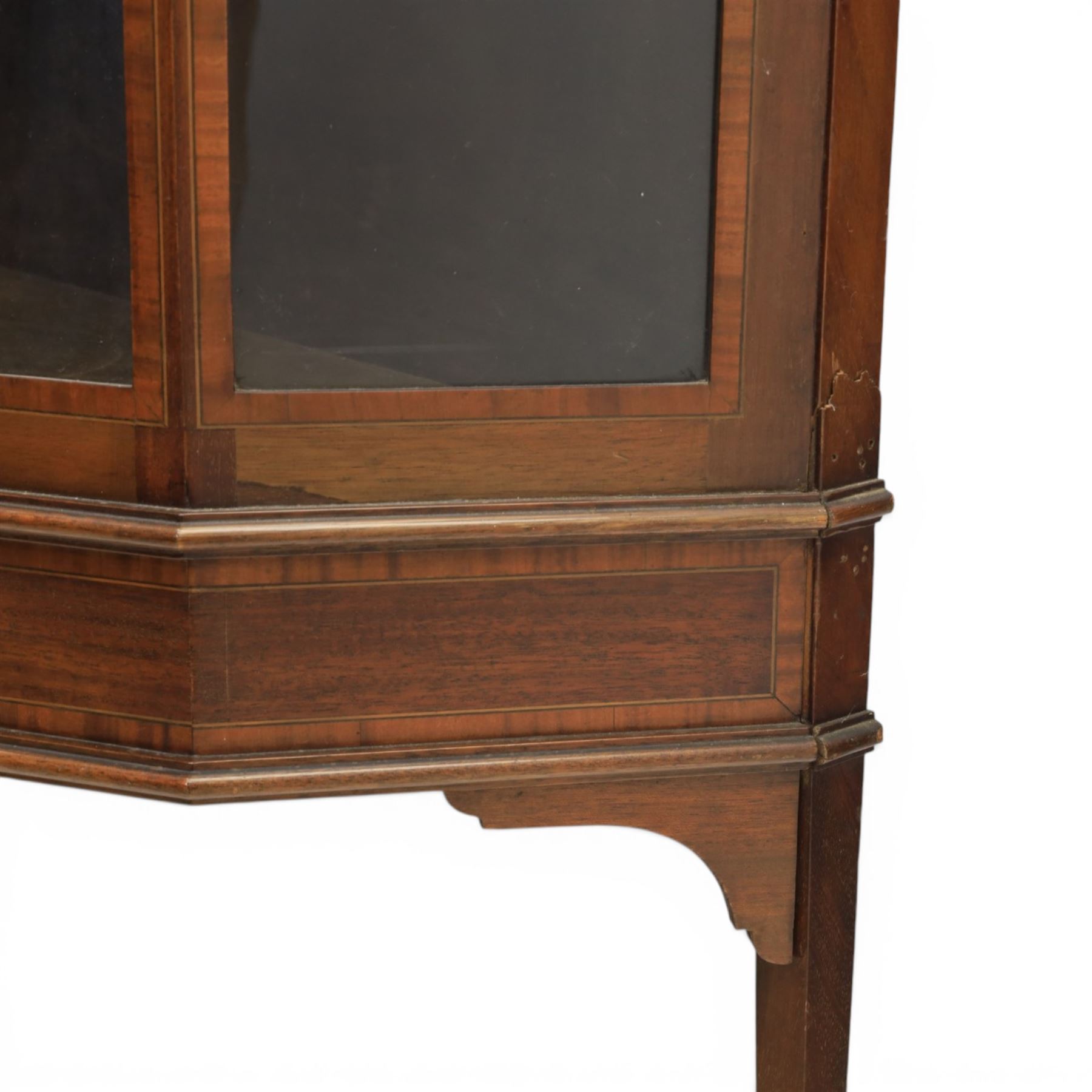 Edwardian inlaid mahogany display cabinet of rectangular canted form, galleried top with crossbanded inlay, above a glazed cabinet enclosing  baize lined shelves, raised on square tapering legs terminating in spade feet  