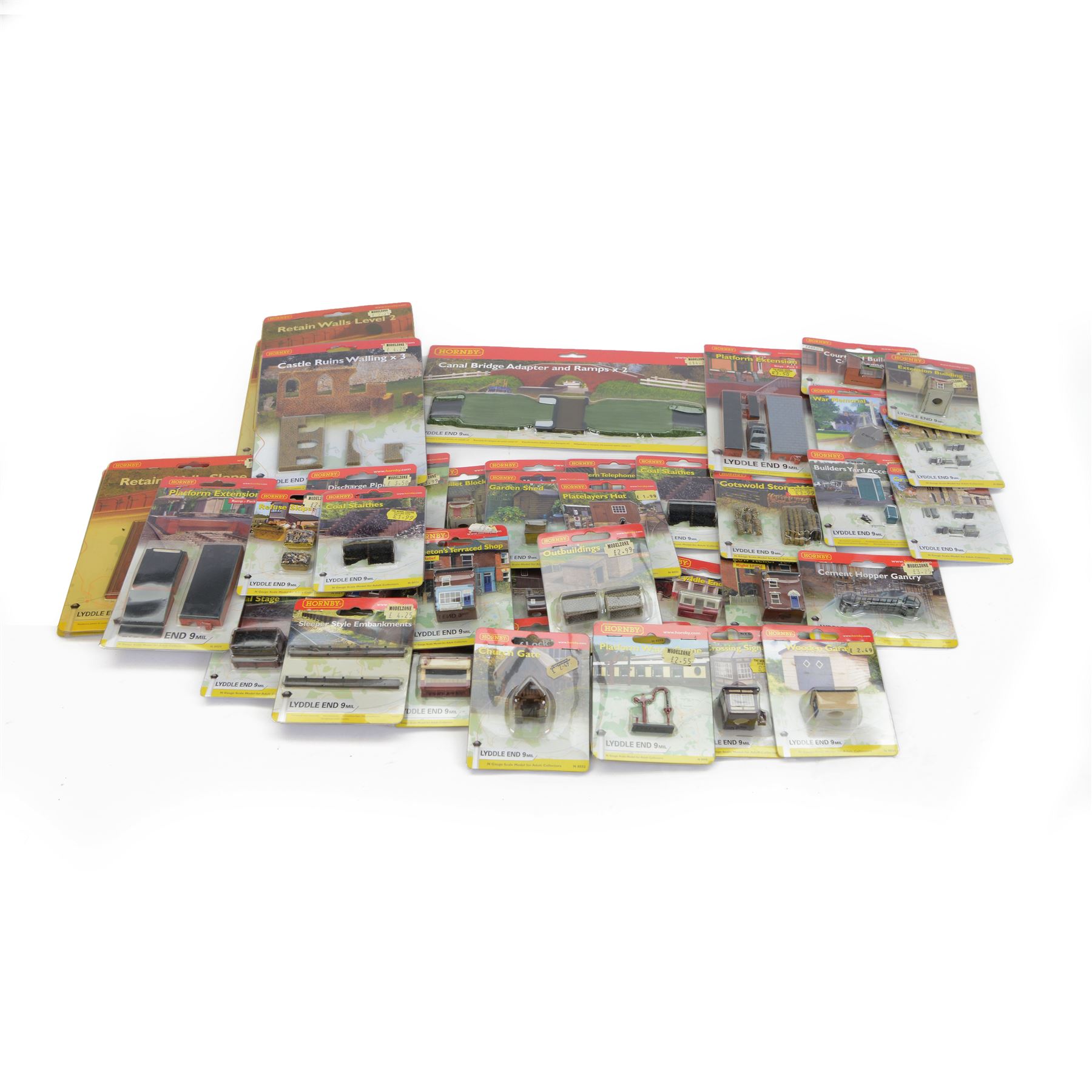 Forty-six Hornby N Gauge Lyddle End model railway trackside buildings and accessories, including N8574 Canal Bridge Adapter and Ramps, N8724 Castle Ruins Walling x 3, N8069 Tractors, N8018 Cotswold Stone Wall and N8096 Low Relief Terrace, all carded