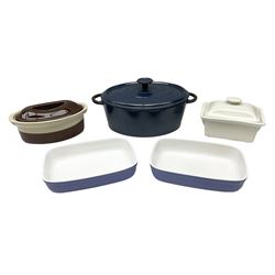Emile Henry covered casserole dish of oval form in two tone brown and cream, no. 03.06, together with cast iron Nomar twin handled lidded casserole dish of oval form in navy, and other ovenware including Flintware ICTC, largest L35cm
