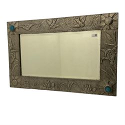Art Nouveau period wall mirror, in repousse and hammered pewter frame decorated with birds and set with mottled blue cabouchons