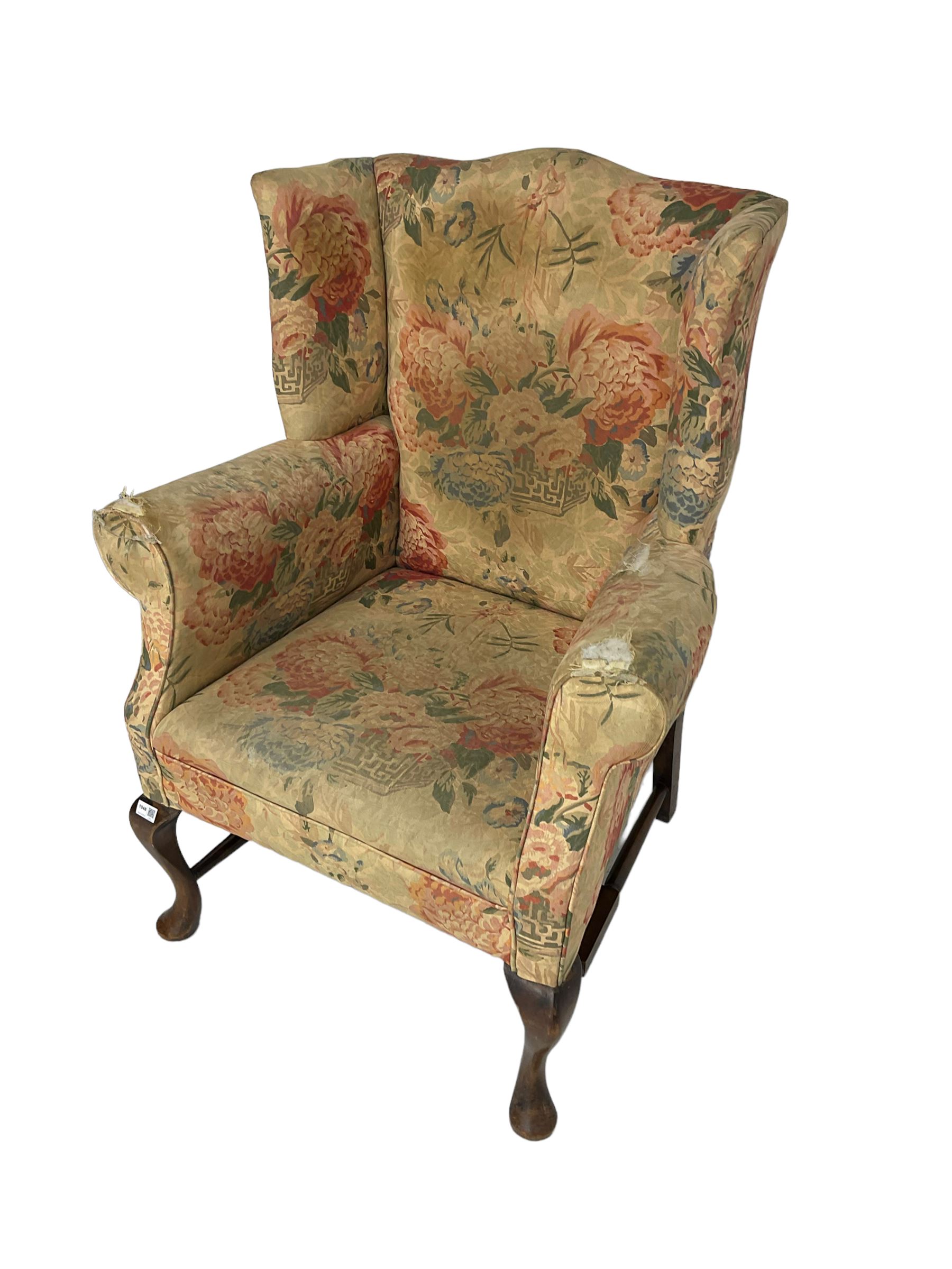 Early 20th century Georgian style wingback armchair, upholstered in floral fabric with sprung seat, walnut frame with front cabriole supports