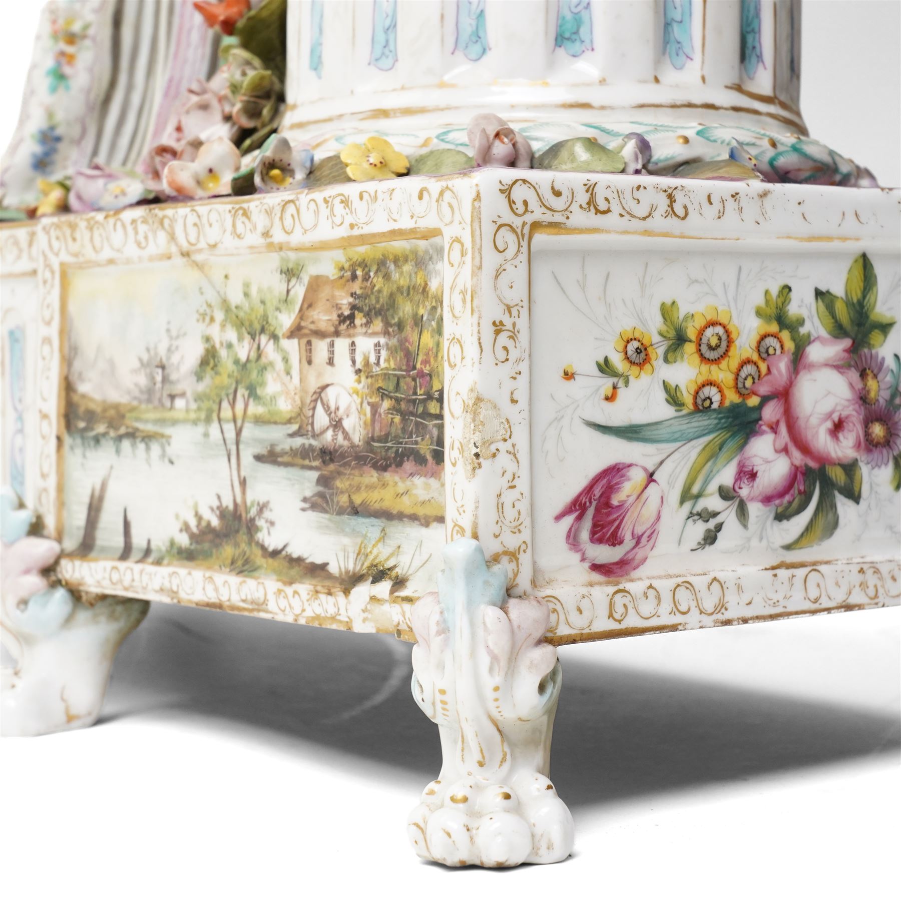Large19th century  German porcelain mantel clock with white dial and striking movement, the case with a standing figure of Flora resting on a pillar with floral applied decoration, the base painted eith landscape and floral panels on paw feet H77cm W43cm