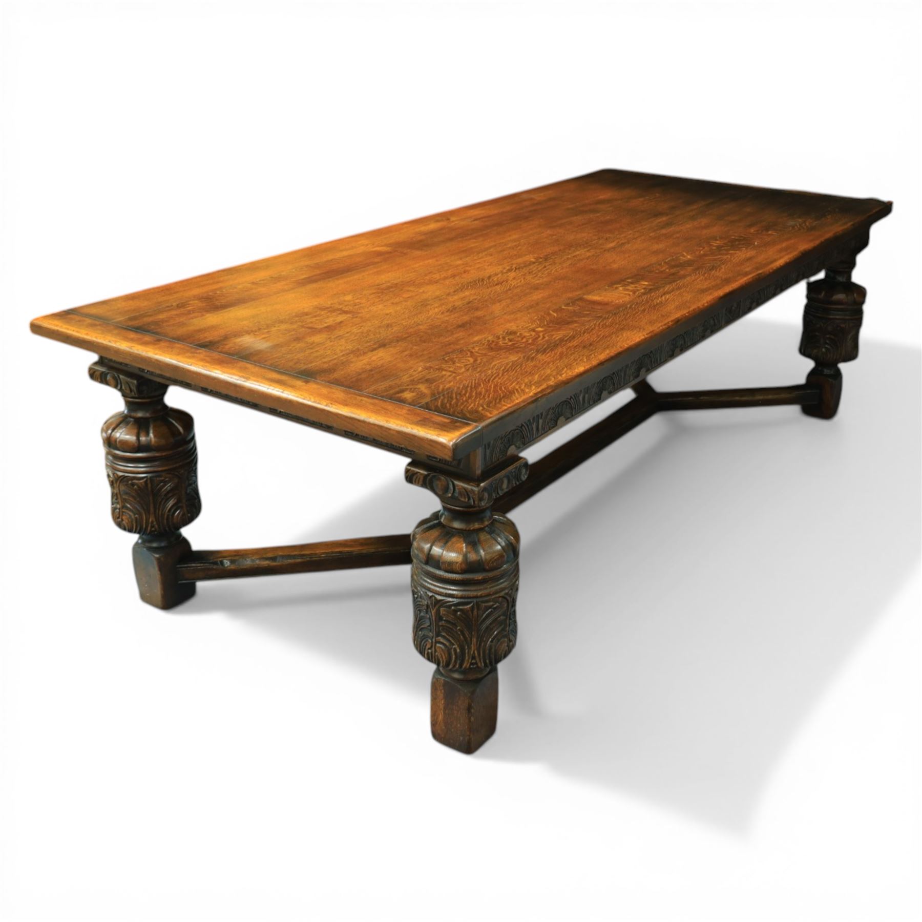 Royal Oak Furniture Co - Jacobean style oak dining table with suite of ten oak high back dining chairs (8+2), rectangular plank top dining table with moulded edge above carved frieze, raised on bulbous turned supports united by stretchers, together with a set of oak framed high back dining chairs including two carvers, upholstered in striped fabric with studded borders, on turned supports united by stretchers 