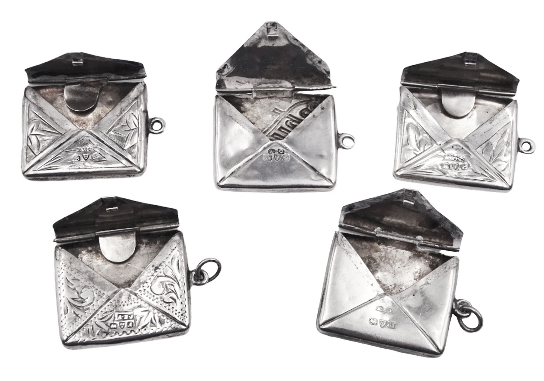 Five early 20th century silver stamp holders modelled in the form of envelopes, comprising three foliate engraved examples, and two plain examples, one with applied detail 'Stamps' verso, hallmarked Albert Ernest Jenkins, (makers mark to one example worn and indistinct),  Chester 1904, 1906, 1908 and 1912, approximate total weight 0.60 ozt (18.6 grams)