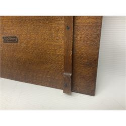 Arts and Crafts oak stand by Arthur Simpson of Kendal, of rectangular form with central hammered pewter panel, surrounded by a border with carved foliate corners, upon two bar supports, bearing label detailed 