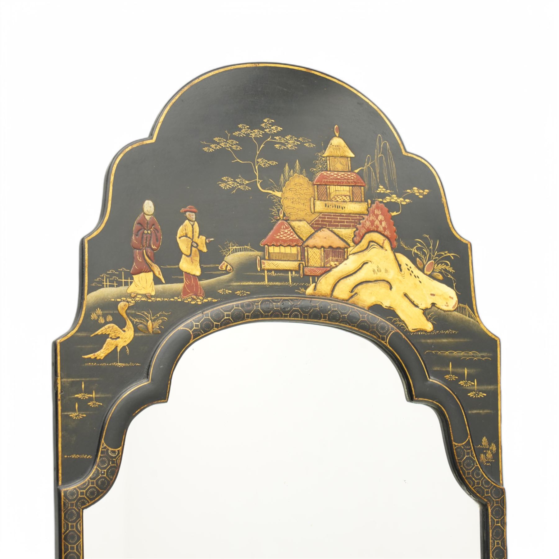 Black lacquered and Chinoiserie wall mirror, the shaped pediment decorated with pagoda in landscape with two figures, plain mirror plate enclosed by moulded surround
