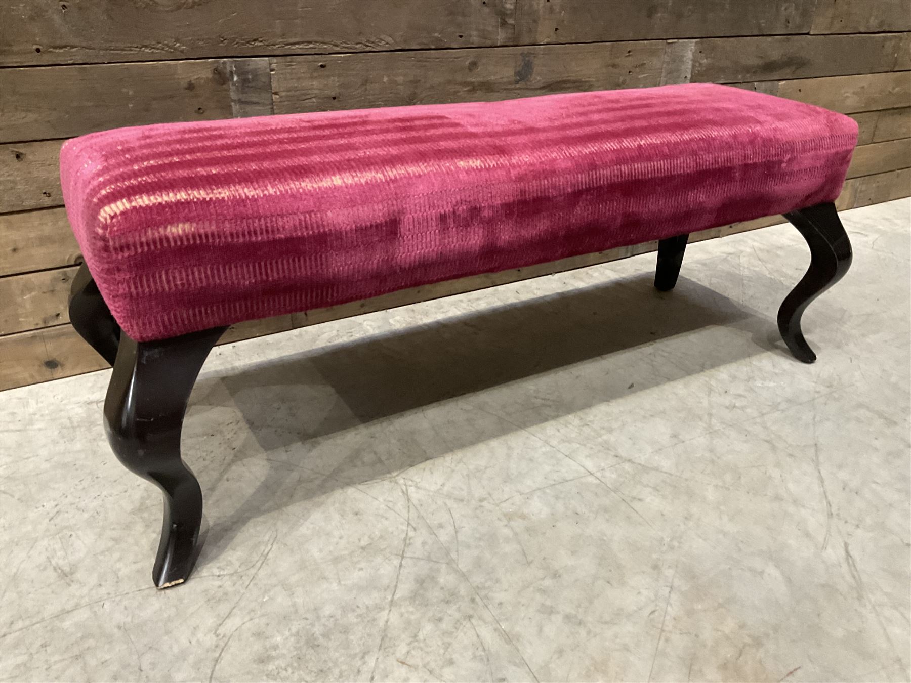 Large rectangular footstool upholstered in a maroon fabric with cabriole supports