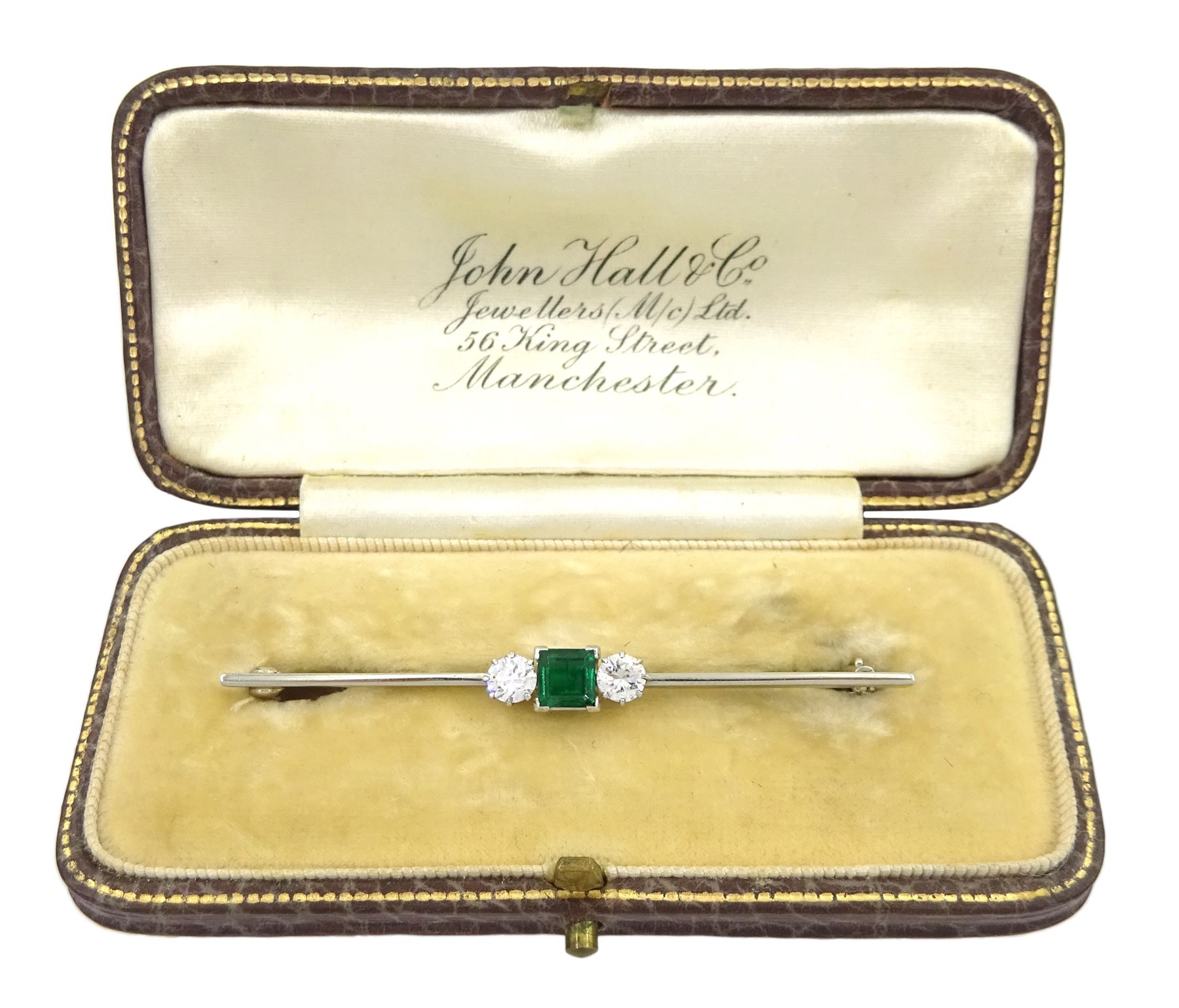 18ct white gold three stone square cut emerald and round brilliant cut diamond brooch, emerald approx 0.50 carat, total diamond weight approx 0.50 carat, in velvet and silk lined case by John Hall, Manchester