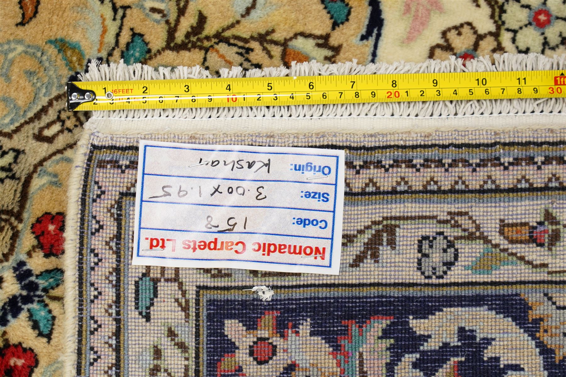 Central Persian Kashan hand-knotted carpet, ivory ground with a central floral medallion with an all-over design of scrolling vinery, palmettes, and flowering sprays i tones of madder red, cobalt, navy blue and sage green, with conforming spandrels, main border of deep indigo ground with repeating palmettes and stylized floral heads, flanked by narrow guard stripes, with cotton fringe ends, with cotton fringe ends 