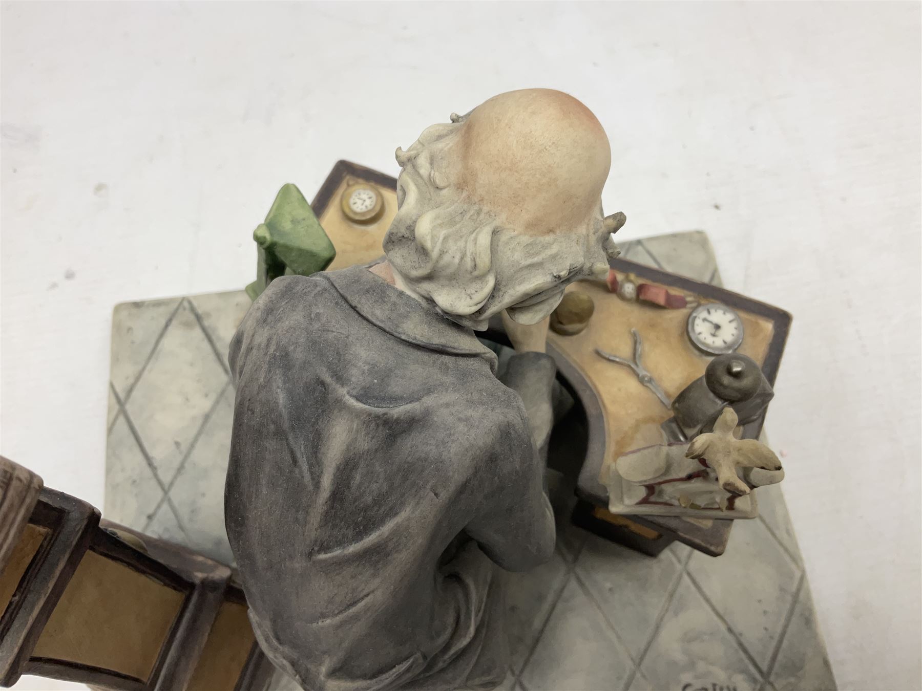 Two Capodimonte figures, comprising The Watchmaker by Curiase and Tramp Seated on a Bench, created by D.Bonalberti, tallest example H24cm