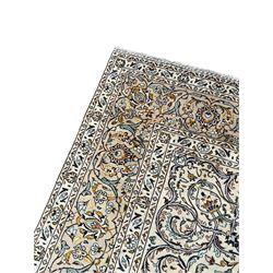 Persian Kashan ivory ground carpet, central pole medallion surrounded by swirling leafy branches and stylised plant motifs, scrolled foliate spandrels, the main border decorated with scrolling pattern and repeating palmettes, within floral patter guard stripes 