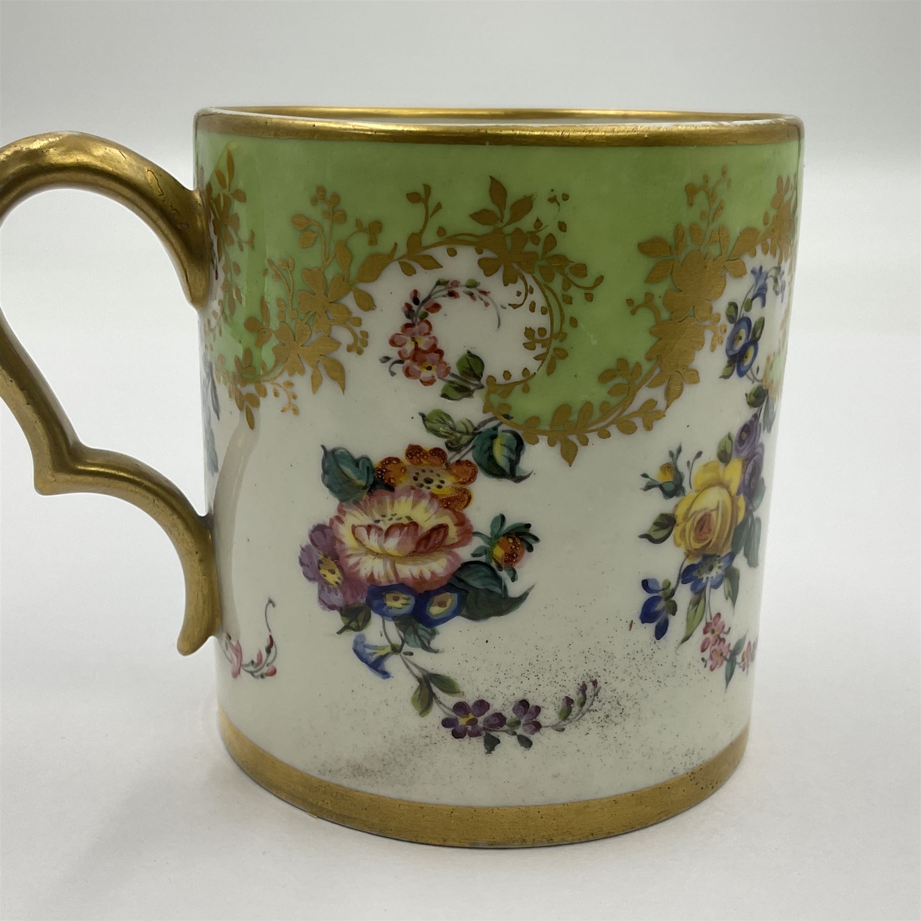 Sèvres soft paste porcelain coffee can and saucer with date code for 1754, painted and gilded with flowers, dangling from the shaped green border, interlaced LL monogram enclosing the date letter A above painters mark for Dodin, coffee can H7cm, saucer D14.5cm