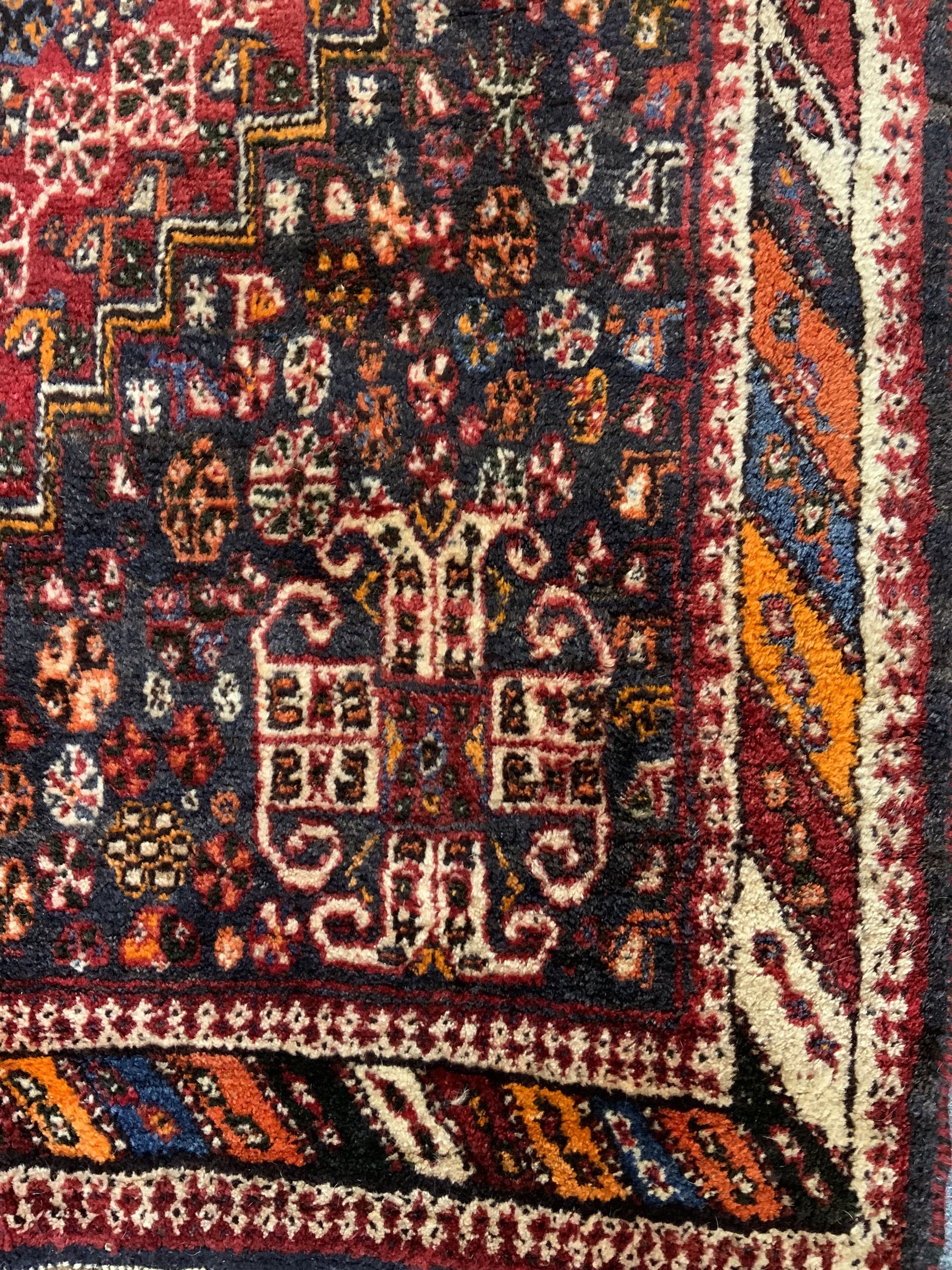 Persian red ground rug carpet, central diamond medallion, multicoloured chequered border